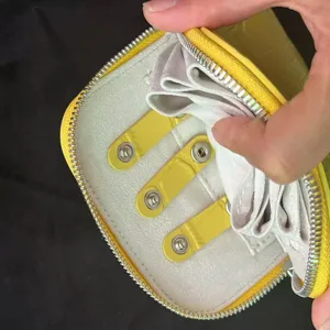 Compact yellow crocodile pattern leather jewelry organizer case with secure zipper and snap buttons.
