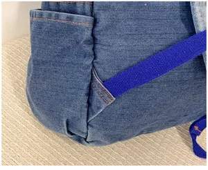 Vue détaillée d'un sac à dos en jean décontracté avec tissu durable, poche latérale et bretelles.
