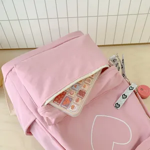 Close-up detail of the pink minimalist college style backpack with a cute heart embroidery.