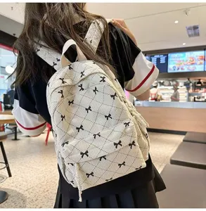Cute corduroy mini backpack featuring black bow patterns, casual stylish school daypack