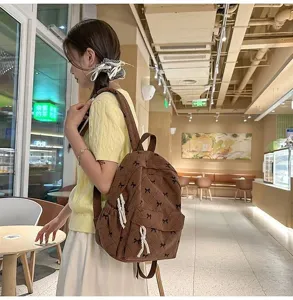 Detail view of the stylish corduroy backpack with cute bow details for casual daily wear.