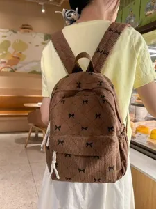 Chic brown corduroy backpack featuring sweet bow patterns, perfect casual school bag for women and girls.