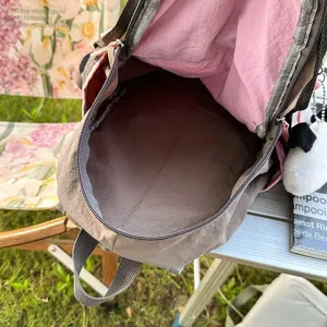 Backpack interior detail showing spacious main compartment and pink lining for daily use.