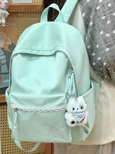 Sac à dos étudiant unicolore minimaliste avec bordure en dentelle et mignon pendentif