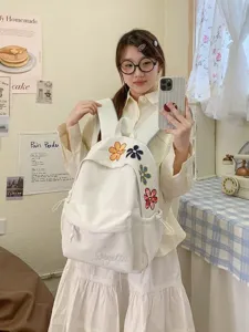White canvas backpack with cute colorful flower embroidery, casual student school bag for daily use.