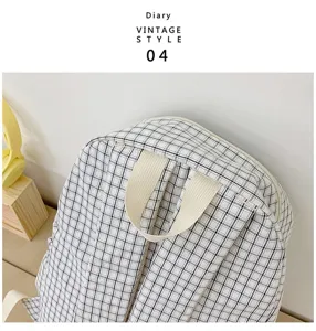 Black and white plaid backpack detail view, featuring durable fabric straps and classic pattern.