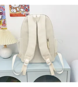 Minimalist solid color backpack detail showing adjustable straps and side pocket design on desk.