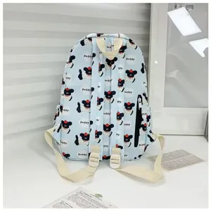 Detail view of the light blue cartoon puppy print backpack, featuring comfortable straps and zipper pocket.