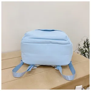 Light blue casual backpack detail view, minimalist solid color student bookbag design.