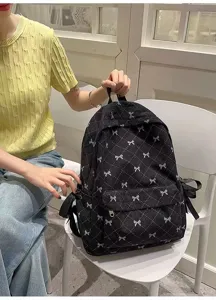 Detailed view of the Korean style black corduroy backpack with cute bow patterns and large capacity.