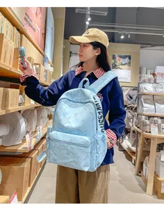 Detail shot of a light blue student backpack with star print, stylish casual commuter daypack.