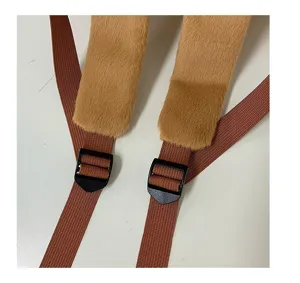 Dettaglio della bretella dello zaino in peluche marrone con texture morbida e fibbia.