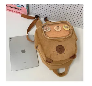 Zaino ita capibara in peluche marrone, dettaglio con finestra trasparente per spille e badge.