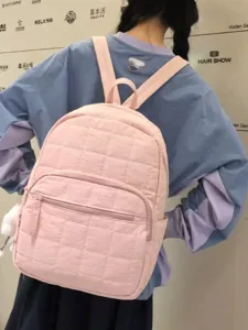 Pink quilted backpack for women, casual minimalist school book bag with front pocket.
