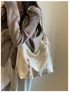 Stylish white motorcycle style shoulder bag for women with metal studs and cute bear pendant.