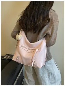 Stylish pink leather shoulder bag featuring metal studs and cute small bear pendant.