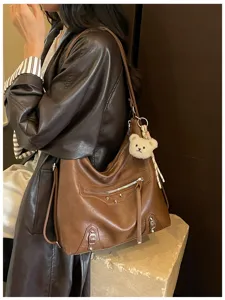 Stylish brown leather hobo shoulder bag with motorcycle style details and a cute bear charm.