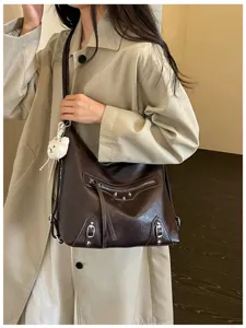 Dark brown multi-use shoulder bag featuring metal studs, zippers and cute plush charm pendant.