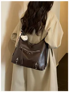 Vintage dark brown leather shoulder bag with zippers, studs and cute bear charm detail.