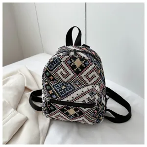Nahaufnahme des retro gewebten Mini-Rucksacks mit bunten geometrischen Mustern und schwarzen Trägern.