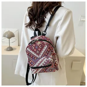Detailansicht eines modischen ethnisch gewebten Mini-Rucksacks am Model mit schöner Textur.