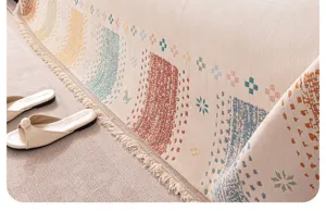 Detailed close-up of a woven dopamine style sofa cover blanket with fringe and texture.