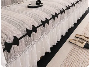 Chenille sofa cover fabric detail, elegant black bow pattern and white mesh skirt hem.