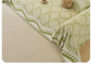 Vista dettagliata di una coperta per divano vintage verde e crema con trama in primo piano.