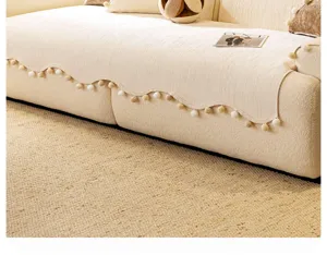 Housse de canapé en chenille épaisse avec franges à pompons, couverture beige confortable de détail.