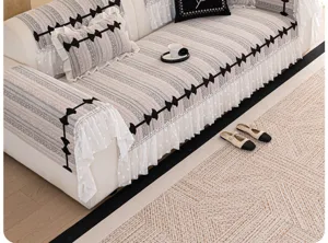 Detailed view of a chenille sofa cover featuring black bow patterns and elegant white lace.