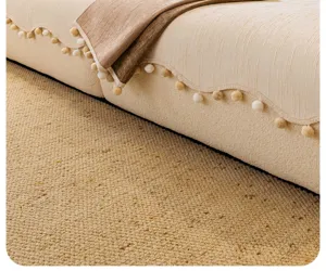 Gros plan détaillé de la housse de canapé en chenille épaisse avec franges douces en pompons.