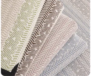 Close-up detail of soft chenille sofa cover fabric featuring elegant herringbone textured weave.