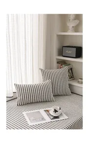 Vue detaillee du coussin de fenetre en chenille avec motif losanges noir et blanc.
