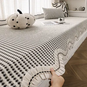 Coussin de fenêtre en chenille à motif géométrique noir et blanc et bord à volants.
