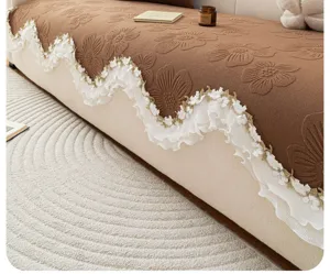 Gedetailleerd overzicht van bruine gewatteerde bankhoes met elegante witte kanten rand.
