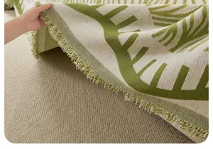 Primo piano della texture del tessuto per copridivano retrò con foglie verdi e frange eleganti.
