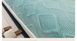 Vue en gros plan de la texture épaisse de la housse de canapé en velours cristal matelassé.