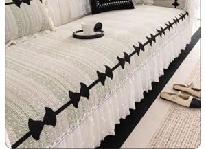 Chenille sofa cover detailed shot showing elegant black bow pattern and white lace skirt.