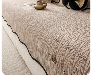 Housse de canapé universelle en chenille avec tissu texturé et bordure design ondulée.