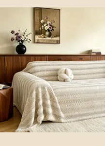 Detailansicht der cremefarbenen strukturierten Sofabezug Decke im gemütlichen Wohnzimmer.