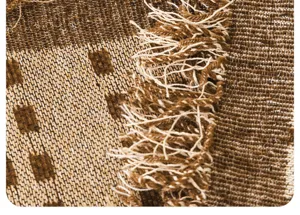 Chenille sofa cover detail shot showcasing textured brown fabric and elegant fringe edge design.