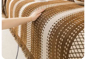 Chenille sofa cover detail showing soft textured brown geometric knit fabric with elegant fringe edge.