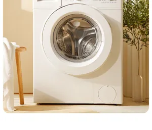 Close-up view of a modern white front-load washing machine in a cozy home laundry setup.