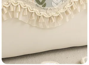 Détail de housse de coussin de canapé en chenille française, élégante dentelle et pompons.