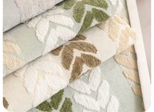 Gros plan détaillé d'un tissu de coussin en chenille française avec motif de feuilles texturées.