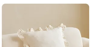 Detailaufnahme des cremefarbenen Kissenbezugs mit Rüschen, weiche Textur für das Wohnzimmer.