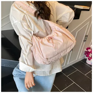 Details van de stijlvolle roze nylon schoudertas met trekkoord die textuur en dagelijks gebruik toont.