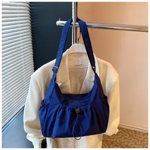 Gedetailleerd overzicht van de blauwe nylon schoudertas met trekkoord voor dagelijks gebruik.