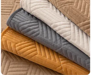 Vue détaillée du tissu de housse de canapé en velours matelassé avec de belles coutures.