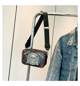 Gedetailleerd shot van Halloween schedel print schoudertas met een verstelbare riem.